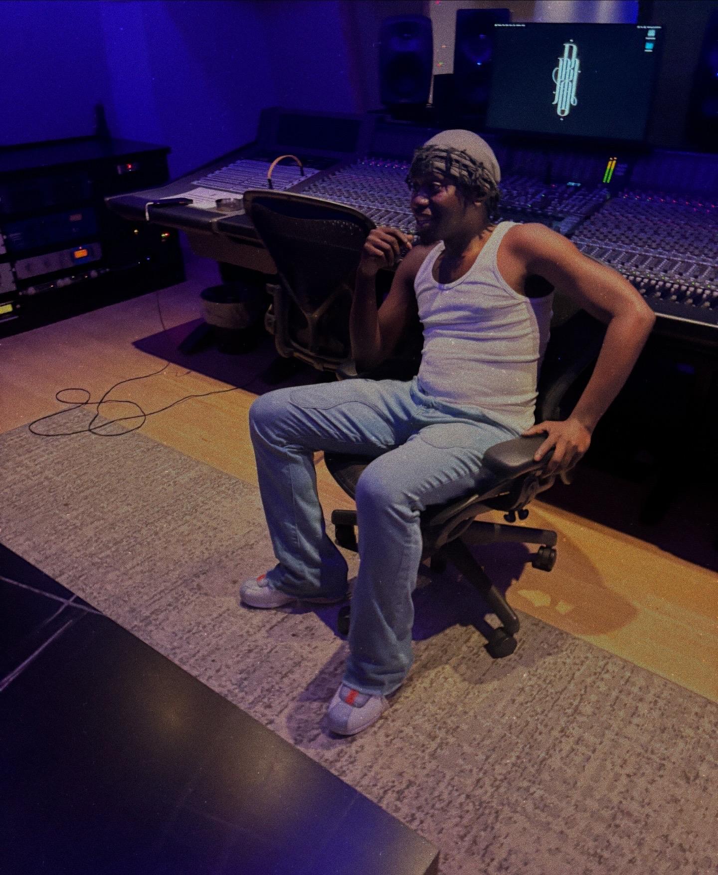 Khali Jah standing at the Studio B desk under purple session lighting.