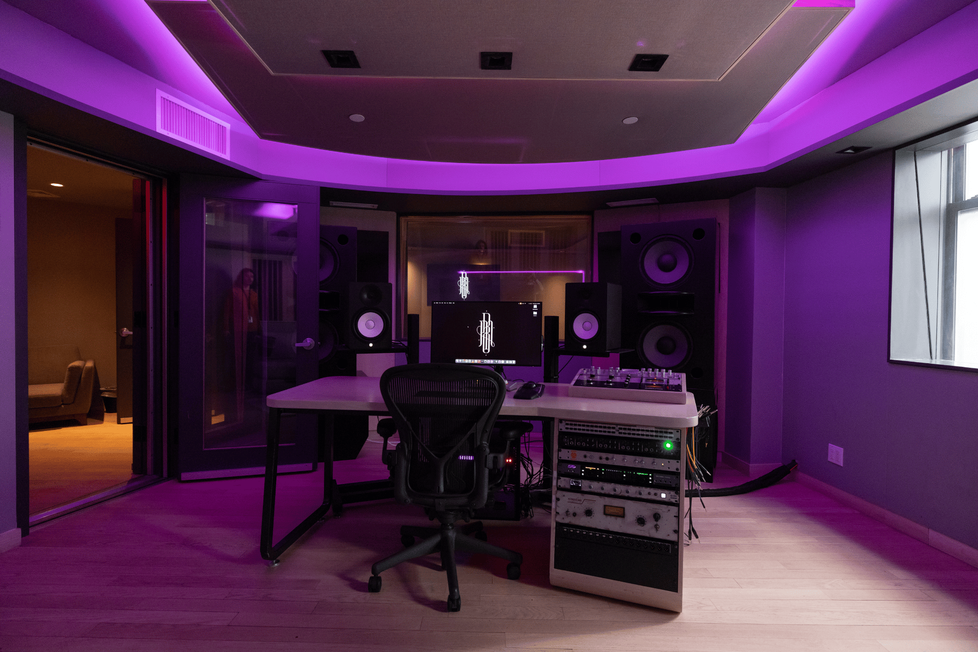 Front-facing Studio D control position with the desk, main speakers, and rack gear.