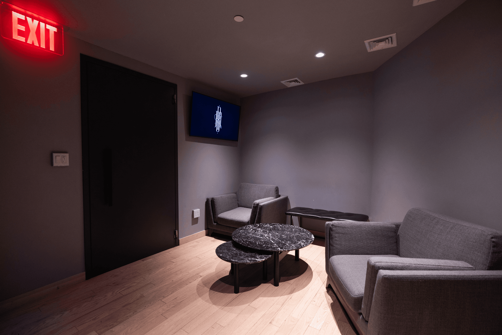 Studio D lounge area with chairs, tables, and wall-mounted display.