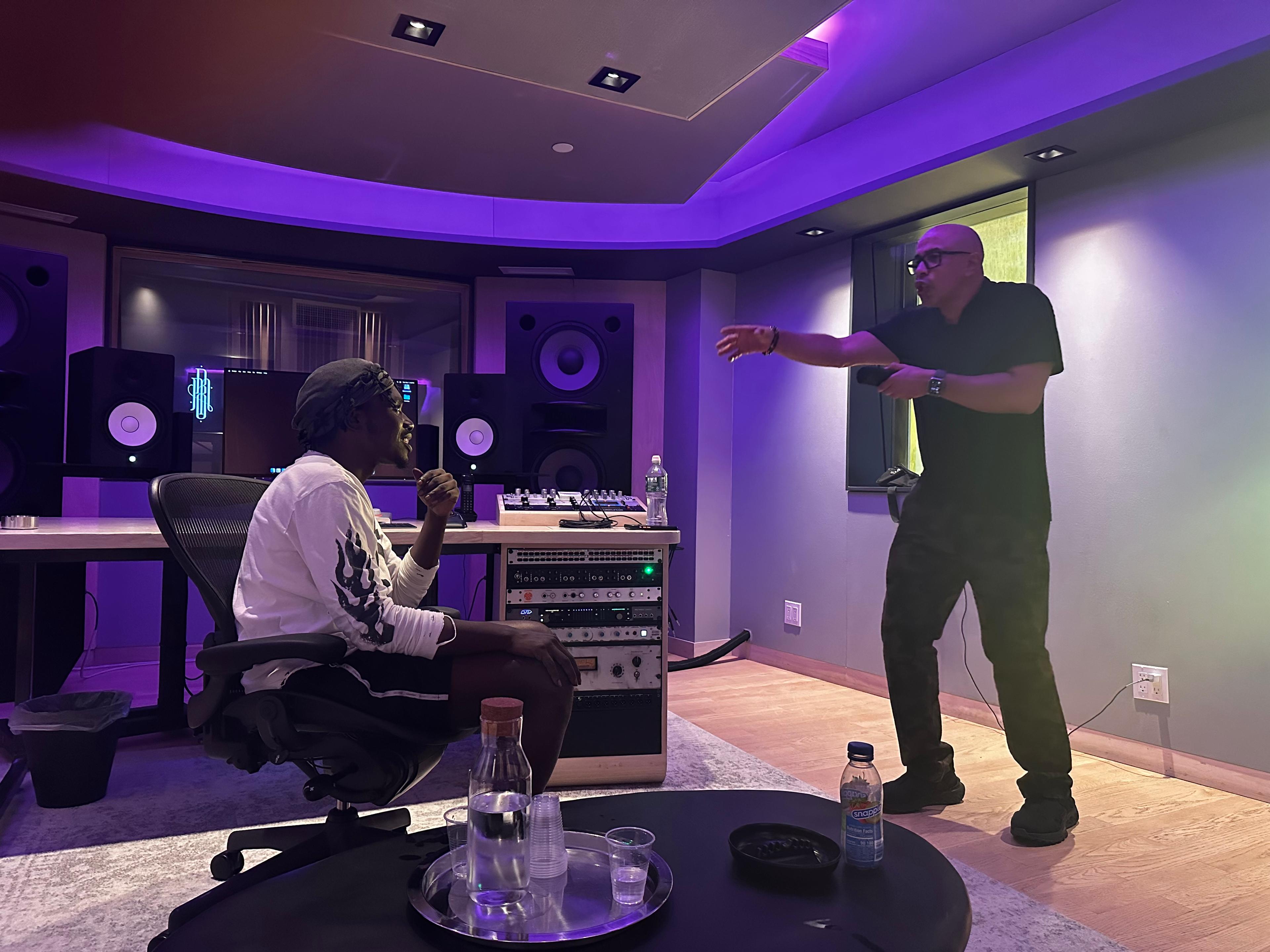 Studio D session moment with two collaborators speaking across the room.